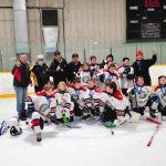 A North Bay Trapper's minor league hockey team on the ice holding up one finger