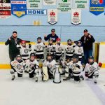 A North Bay Trapper's minor league hockey team on the ice posing with a trophy and medals